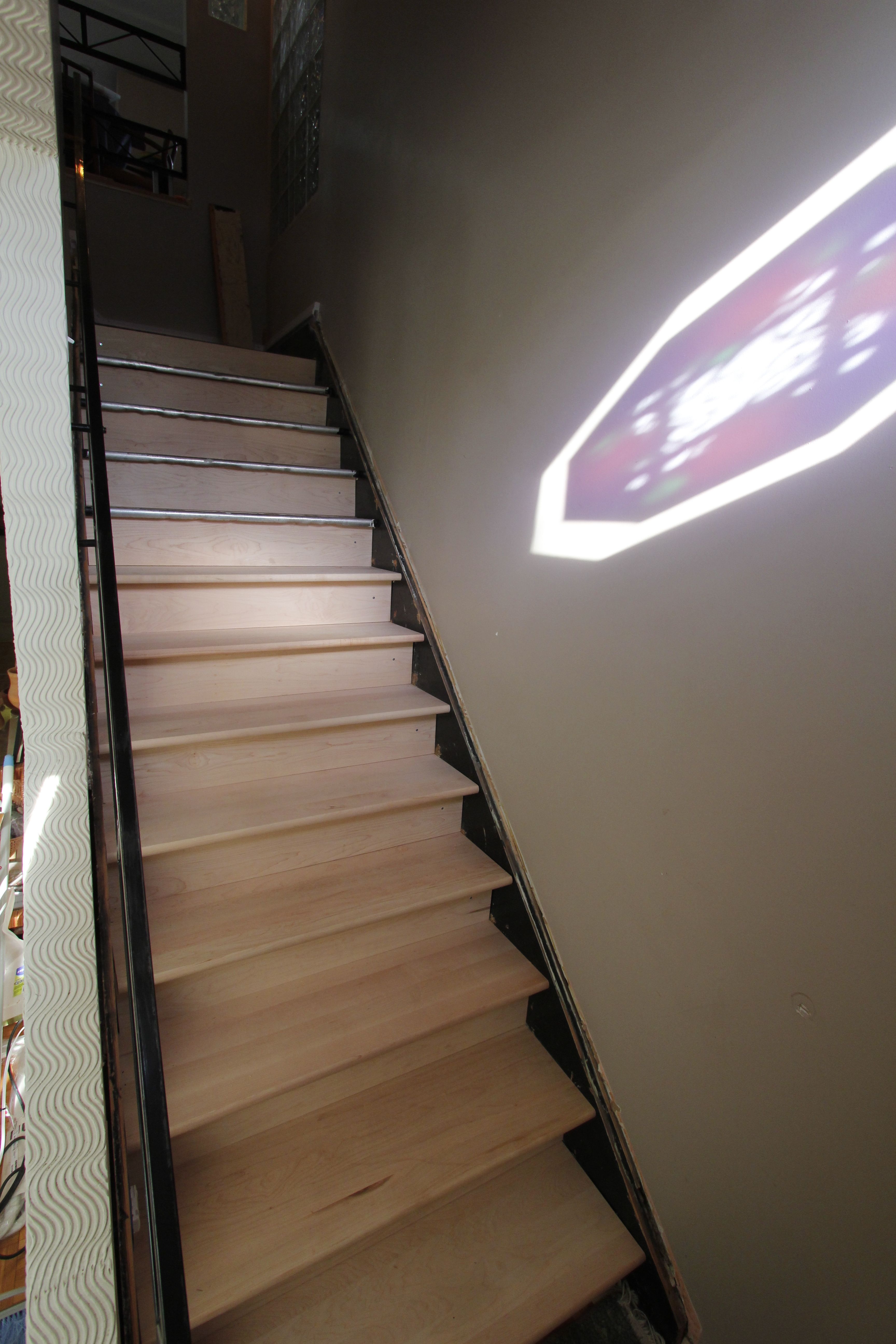 The main stairway, with eight of the twelve steps temporarily placed.  The light on the wall is the sun shining through a stained glass feature above the entry door.