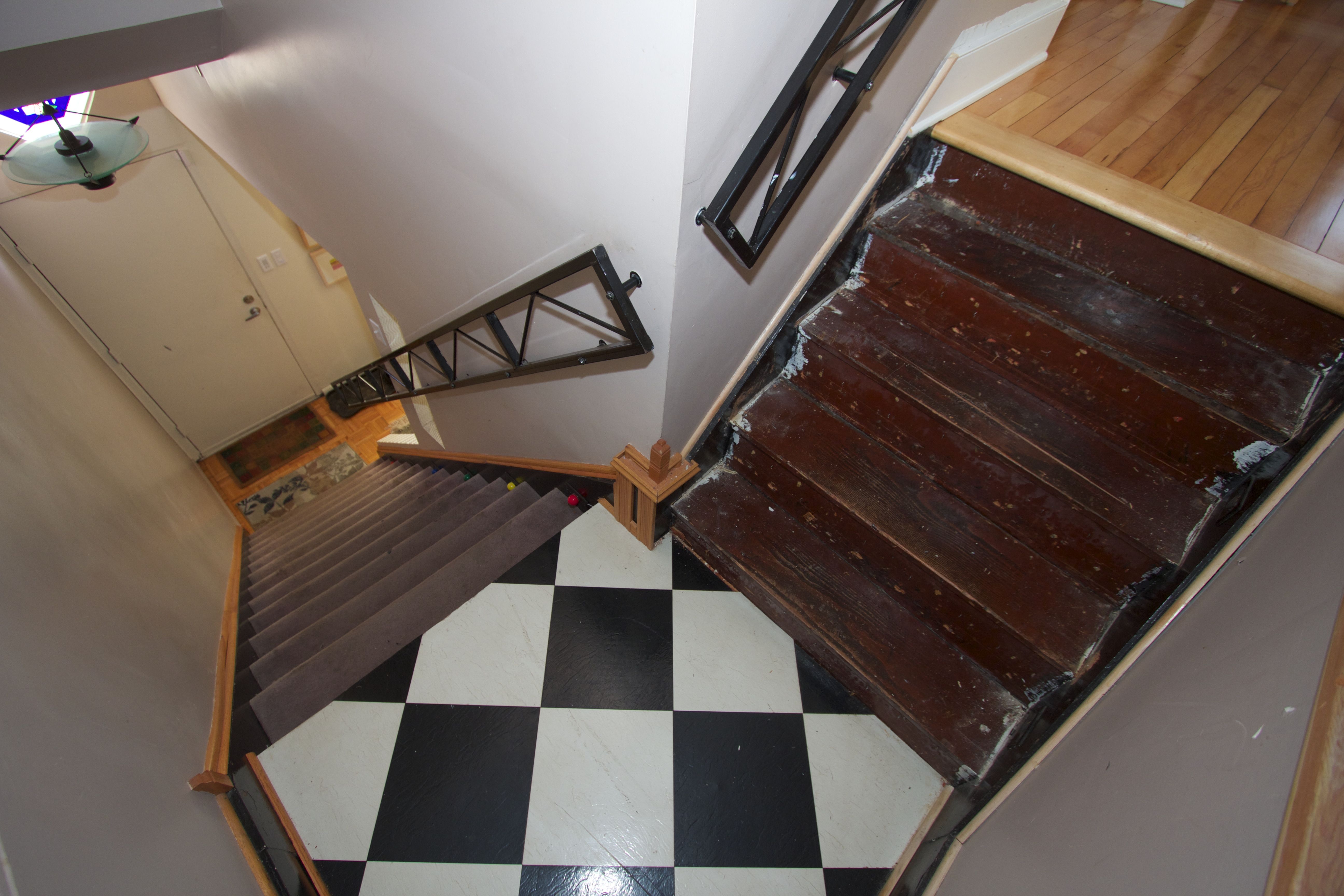 The original stairway landing of black and white vinyl tiles.